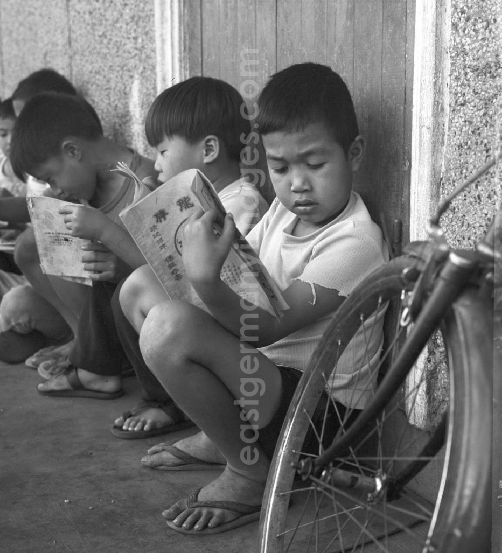 Vientiane: Kinder lesen am Rande des Marktes in Vientiane in der Demokratischen Volksrepublik Laos.