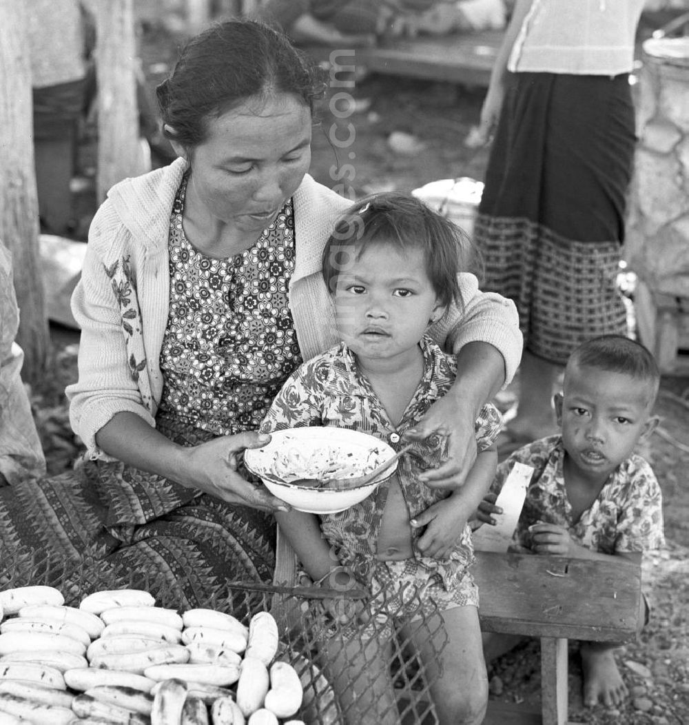 GDR picture archive: Vientiane - Frau mit Kindern hinter ihrem Marktstand in Vientiane, der Hauptstadt der Demokratischen Volksrepublik Laos.