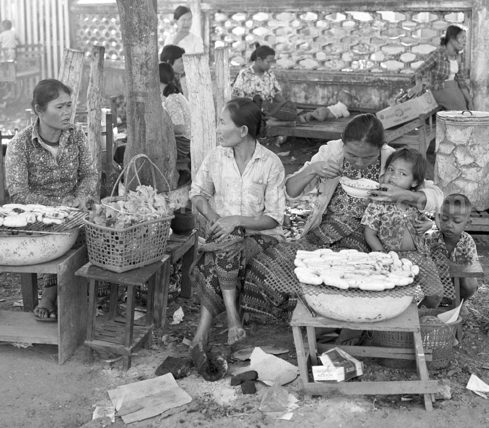 Vientiane: Frauen mit ihren Kindern verkaufen Lebensmittel an Marktständen in Vientiane, der Hauptstadt der Demokratischen Volksrepublik Laos.