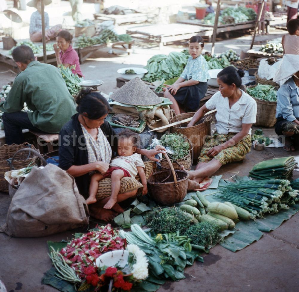 GDR image archive: Vientiane - Ein Baby schläft auf dem Schoß seiner Mutter auf einem Markt in Vientiane in der Demokratischen Volksrepublik Laos.