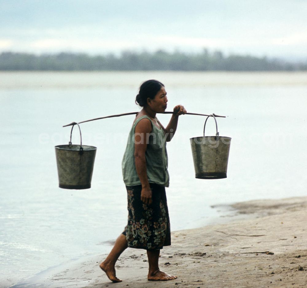 Ang Nam Ngum: Frau holt mit Eimern Wasser im Fluß Mekong in der Demokratischen Volksrepublik Laos.