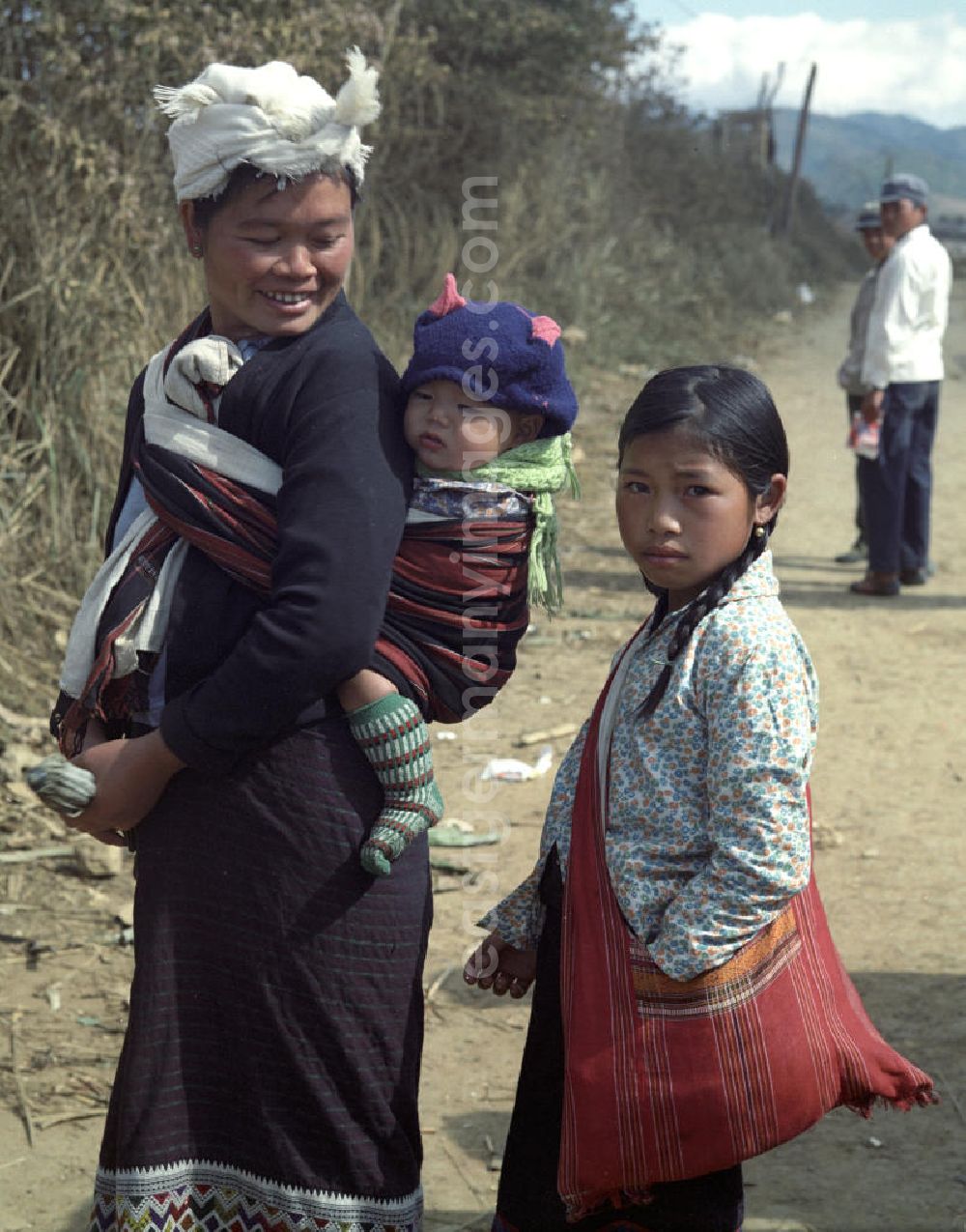 Xieng Khouang: Frauen und Kinder aus dem Volksstamm der Meo (auch Hmong) auf einer Straße nahe sogenannten Ebene der Tonkrüge in der Provinz Xieng Khouang in der Demokratischen Volksrepublik Laos. Die Hmong waren im Vietnam-Krieg involviert. In dessen Folge gehörten sie zu einer verfolgten und zurückgezogen lebenden Minderheit in Laos.