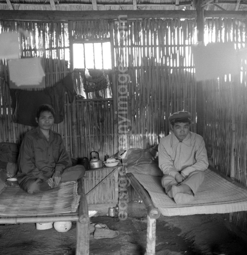 GDR picture archive: Xieng Khouang - Männer aus dem Volksstamm der Meo (auch Hmong) im Kreiskrankenhaus in einem Dorf an der sogenannten Ebene der Tonkrüge in der Provinz Xieng Khouang in der Demokratischen Volksrepublik Laos. Die Hmong gehörten zu einer infolge des Vietnam-Krieges verfolgten und zurückgezogen lebenden Minderheit in Laos.
