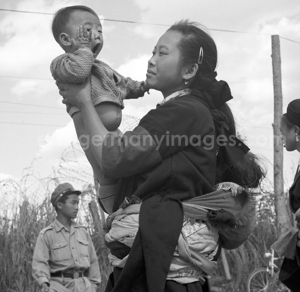 GDR photo archive: Xieng Khouang - Frau mit Baby aus dem Volksstamm der Meo (auch Hmong) auf einer Straße nahe sogenannten Ebene der Tonkrüge in der Provinz Xieng Khouang in der Demokratischen Volksrepublik Laos. Die Hmong waren im Vietnam-Krieg involviert. In dessen Folge gehörten sie zu einer verfolgten und zurückgezogen lebenden Minderheit in Laos.