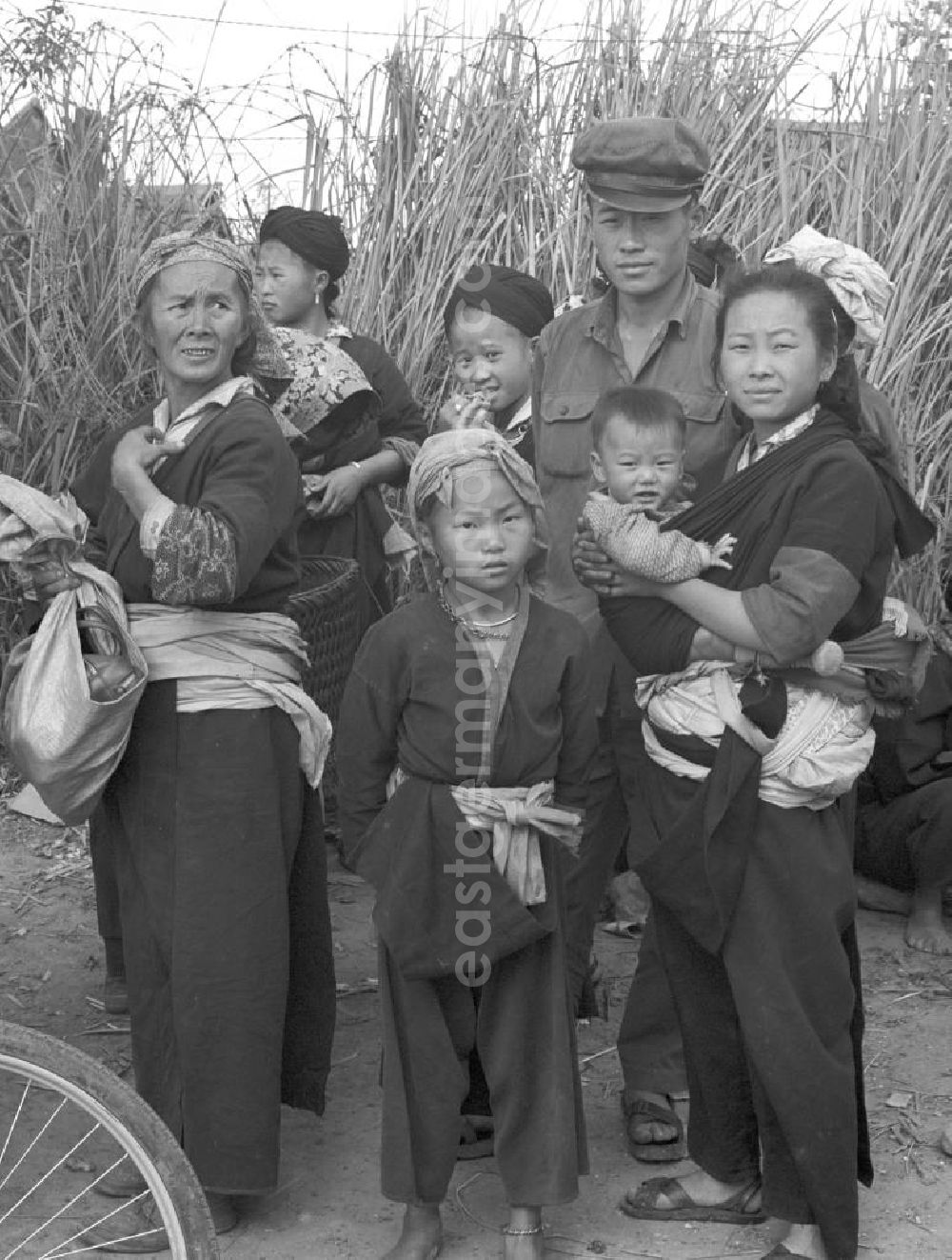 GDR picture archive: Xieng Khouang - Frauen und Soldaten aus dem Volksstamm der Meo (auch Hmong) auf einer Straße nahe sogenannten Ebene der Tonkrüge in der Provinz Xieng Khouang in der Demokratischen Volksrepublik Laos. Die Hmong waren im Vietnam-Krieg involviert. In dessen Folge gehörten sie zu einer verfolgten und zurückgezogen lebenden Minderheit in Laos.