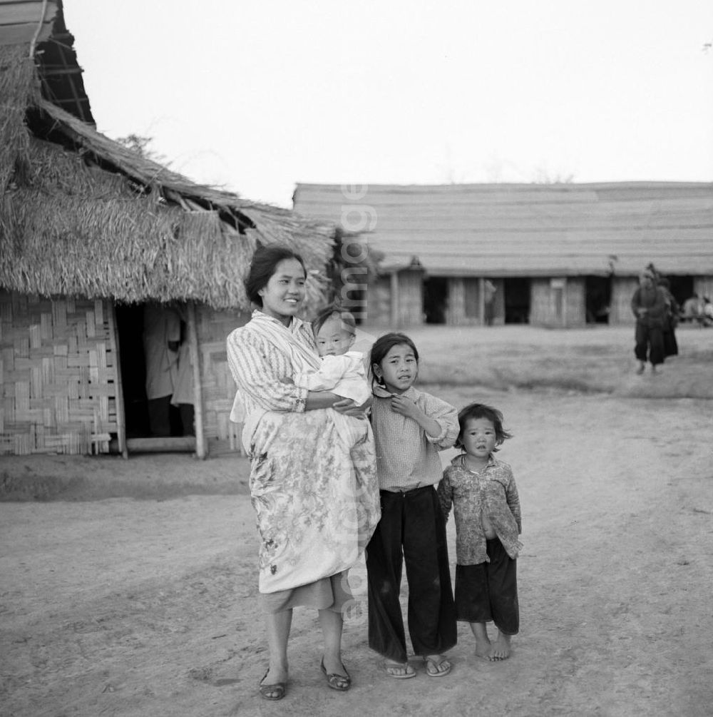 GDR image archive: Xieng Khouang - Frauen und Kinder aus dem Volksstamm der Meo (auch Hmong) vor einer Hütte an der sogenannten Ebene der Tonkrüge in der Provinz Xieng Khouang in der Demokratischen Volksrepublik Laos. Die Hmong gehörten zu einer infolge des Vietnam-Krieges verfolgten und zurückgezogen lebenden Minderheit in Laos.