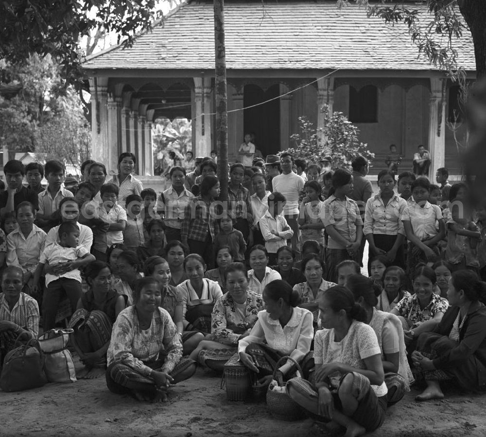 GDR photo archive: Vientiane - Ein feierlicher Empfang erwartet die umerzogenen Rückkehrer von der Frauen- und Männerinsel in Vientiane in der Demokratischen Volksrepublik Laos. Das Nam Ngum Reservoir entstand mit der Fertigstellung des gleichnamigen Staudamms im Jahr 1971. Die im See liegenden Inseln dienten in den 7