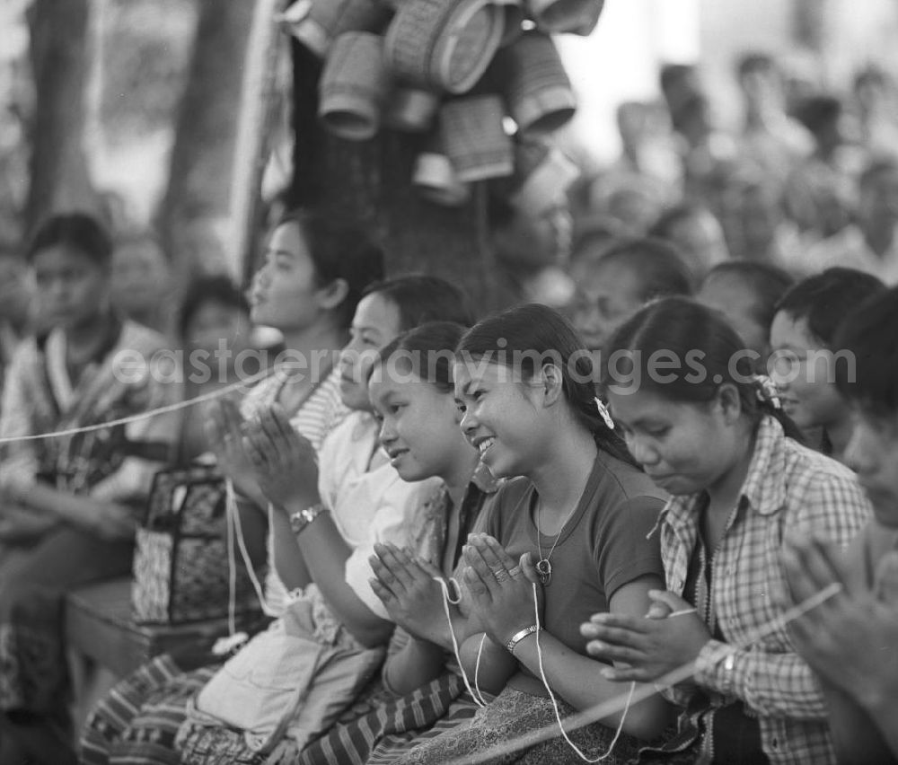 Vientiane: Ein feierlicher Empfang erwartet die umerzogenen Rückkehrer von der Frauen- und Männerinsel in Vientiane in der Demokratischen Volksrepublik Laos. Das Nam Ngum Reservoir entstand mit der Fertigstellung des gleichnamigen Staudamms im Jahr 1971. Die im See liegenden Inseln dienten in den 7