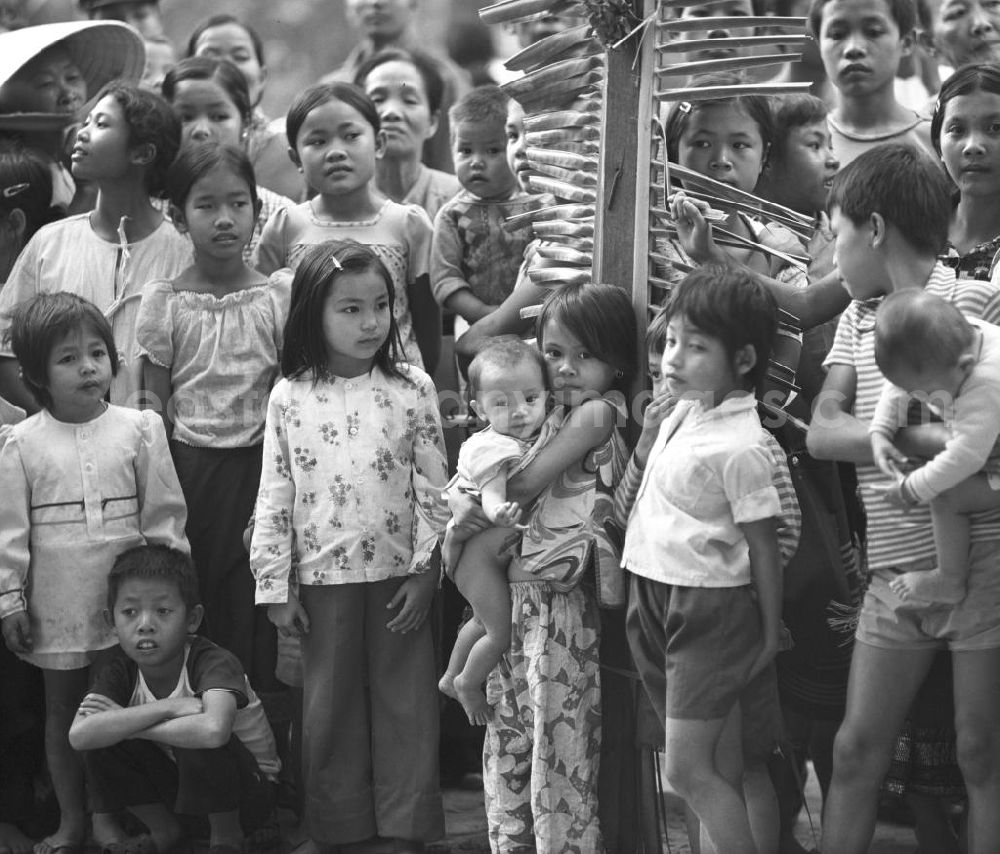 GDR image archive: Vientiane - Ein feierlicher Empfang erwartet die umerzogenen Rückkehrer von der Frauen- und Männerinsel in Vientiane in der Demokratischen Volksrepublik Laos. Das Nam Ngum Reservoir entstand mit der Fertigstellung des gleichnamigen Staudamms im Jahr 1971. Die im See liegenden Inseln dienten in den 7