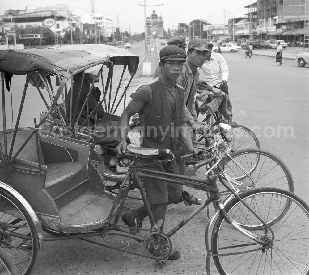 GDR photo archive: Vientiane - Rikschafahrer stehen an einer Straße in Vientiane, der Hauptstadt der Demokratischen Volksrepublik Laos.