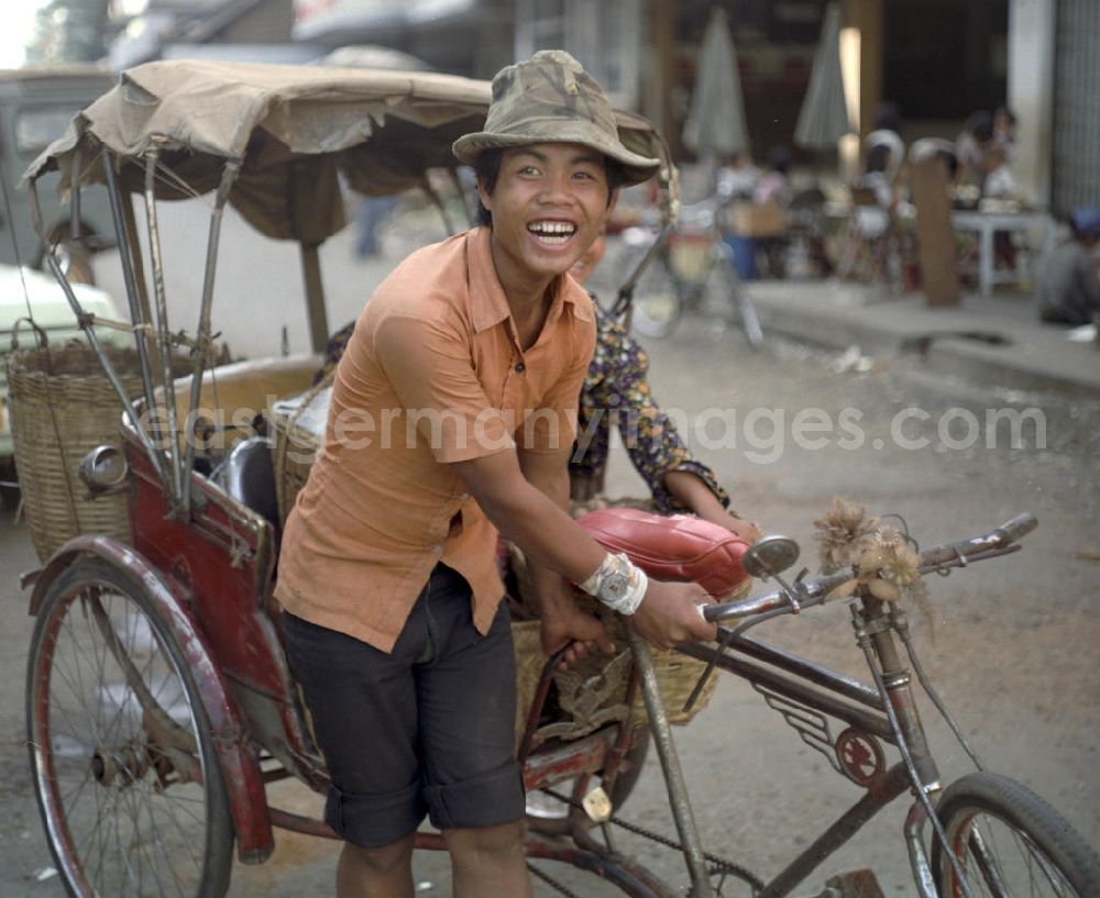 GDR picture archive: Vientiane - Rikschafahrer auf einer Straße in Vientiane in der Demokratischen Volksrepublik Laos.