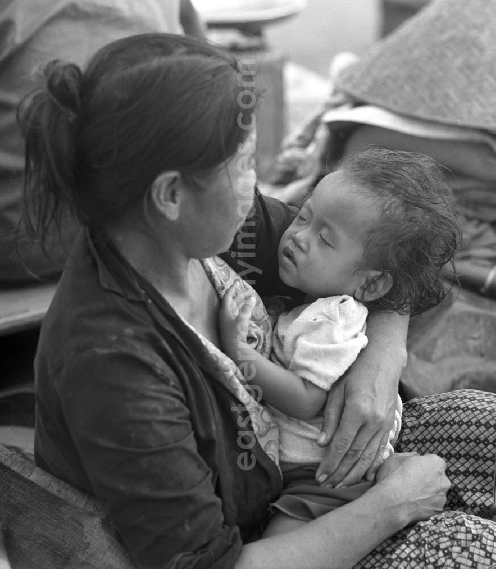 Vientiane: Ein kleines Kind ist auf dem Arm seiner Mutter eingeschlafen - Marktszene in Vientiane, der Hauptstadt der Demokratischen Volksrepublik Laos.