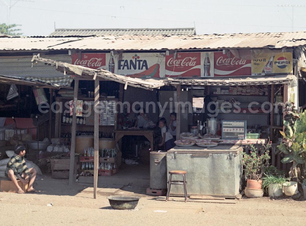 GDR picture archive: Vientiane - Coca Cola, Fanta und Pepsi steht über diesem Ladengeschäft, die verfallene Auslage deutet auf den Standort - ein Slumviertel in Vientiane, der Hauptstadt der Demokratischen Volksrepublik Laos.