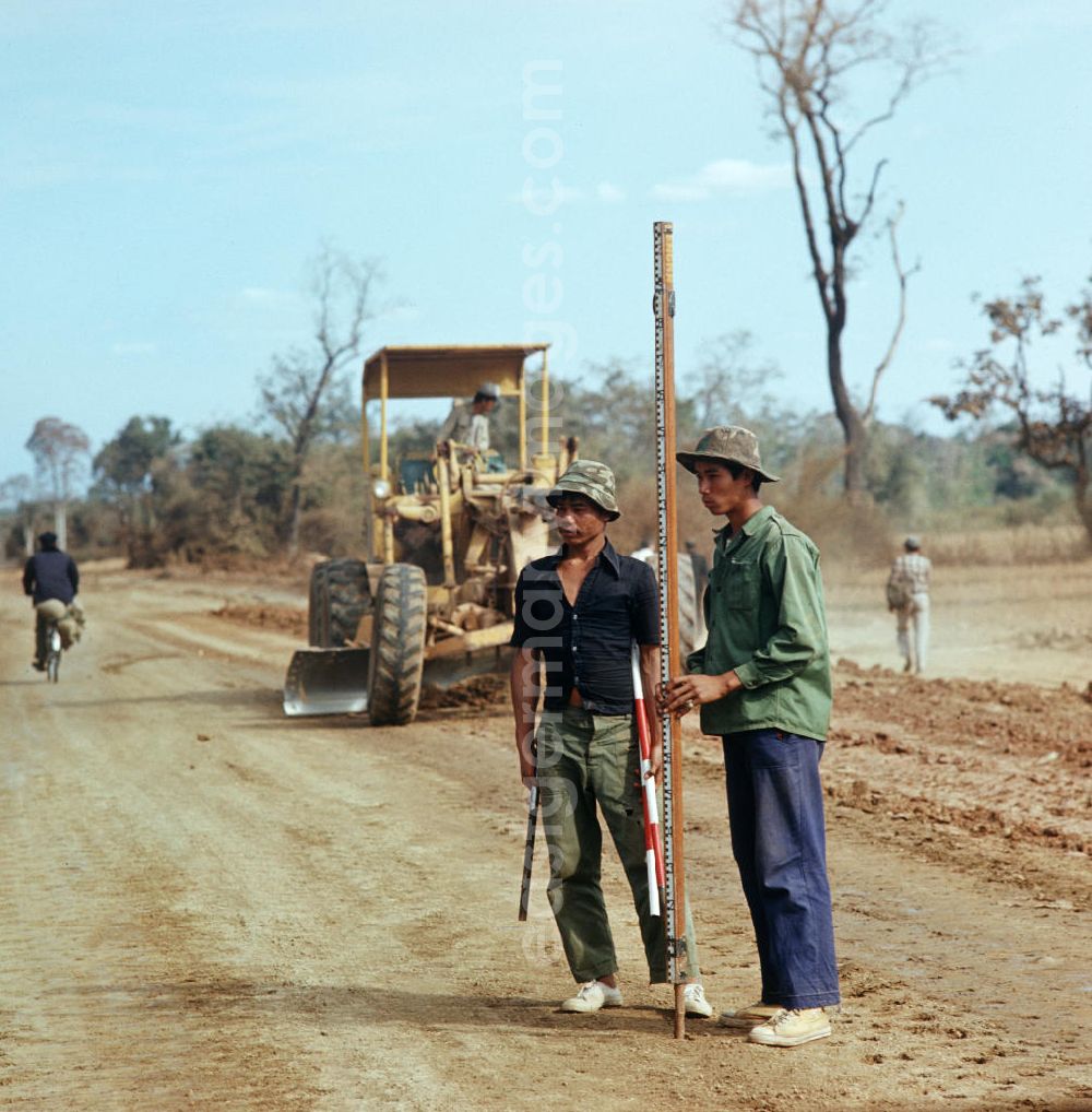 Ang Nam Ngum: Arbeiter mit Vermessungsstange beim Straßenbau in der Demokratischen Volksrepublik Laos.