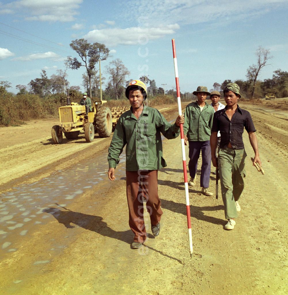 GDR picture archive: Ang Nam Ngum - Ein Arbeiter mit Vermessungsstange beim Straßenbau in der Demokratischen Volksrepublik Laos.