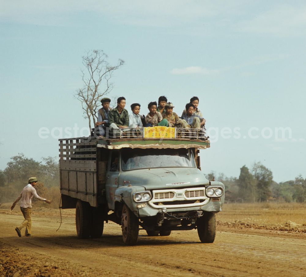 GDR photo archive: Ang Nam Ngum - Mit Waren und Menschen vollbeladener Transporter auf einer Straße in der Demokratischen Volksrepublik Laos.