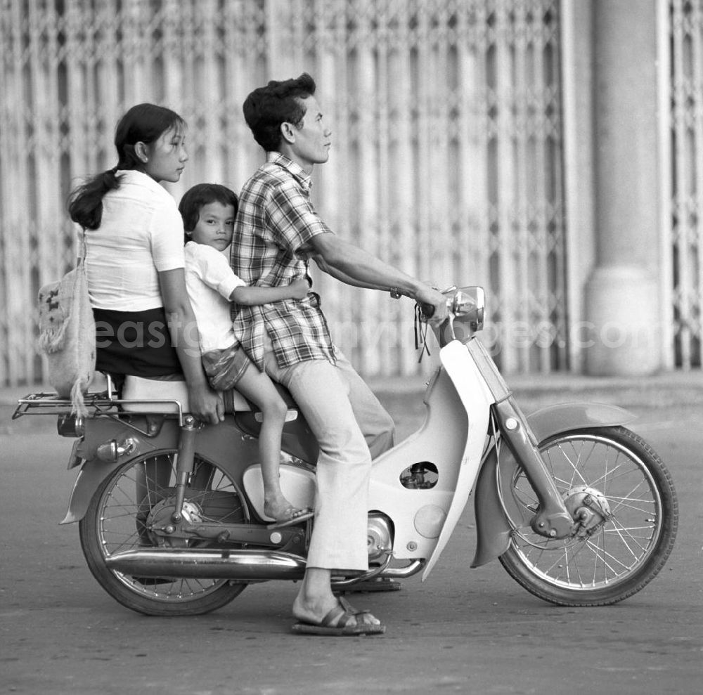 Vientiane: Die ganze Familie fährt mit auf einem Moped auf einer Straße in Vientiane, der Hauptstadt der Demokratischen Volksrepublik Laos.
