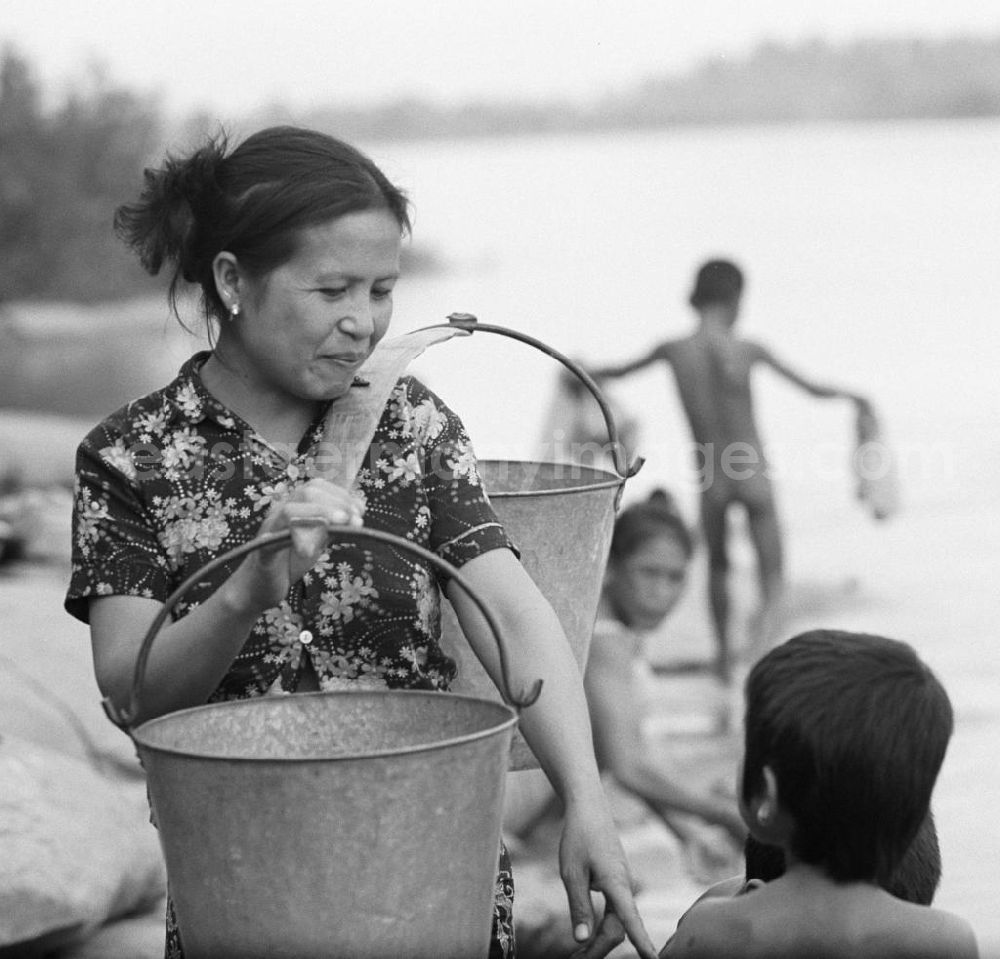 GDR photo archive: Nam Ngum - Frauen baden ihre Kinder und waschen ihre Wäsche im Fluß Mekong in der Demokratischen Volksrepublik Laos.