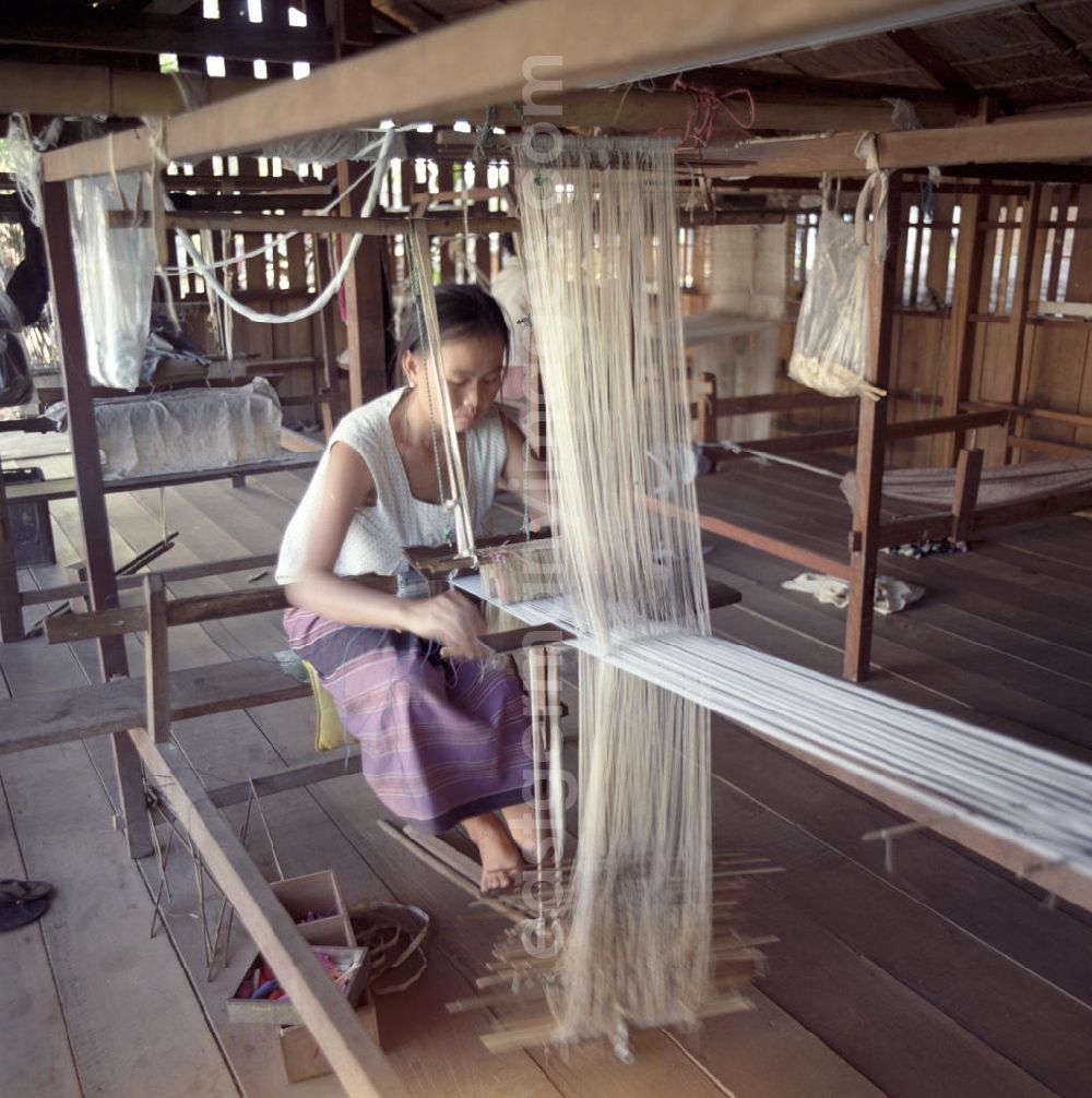 Vientiane: Eine Frau webt an einem Holzwebstuhl in einer Weberei in Vientiane, der Hauptstadt der Demokratischen Volksrepublik Laos.