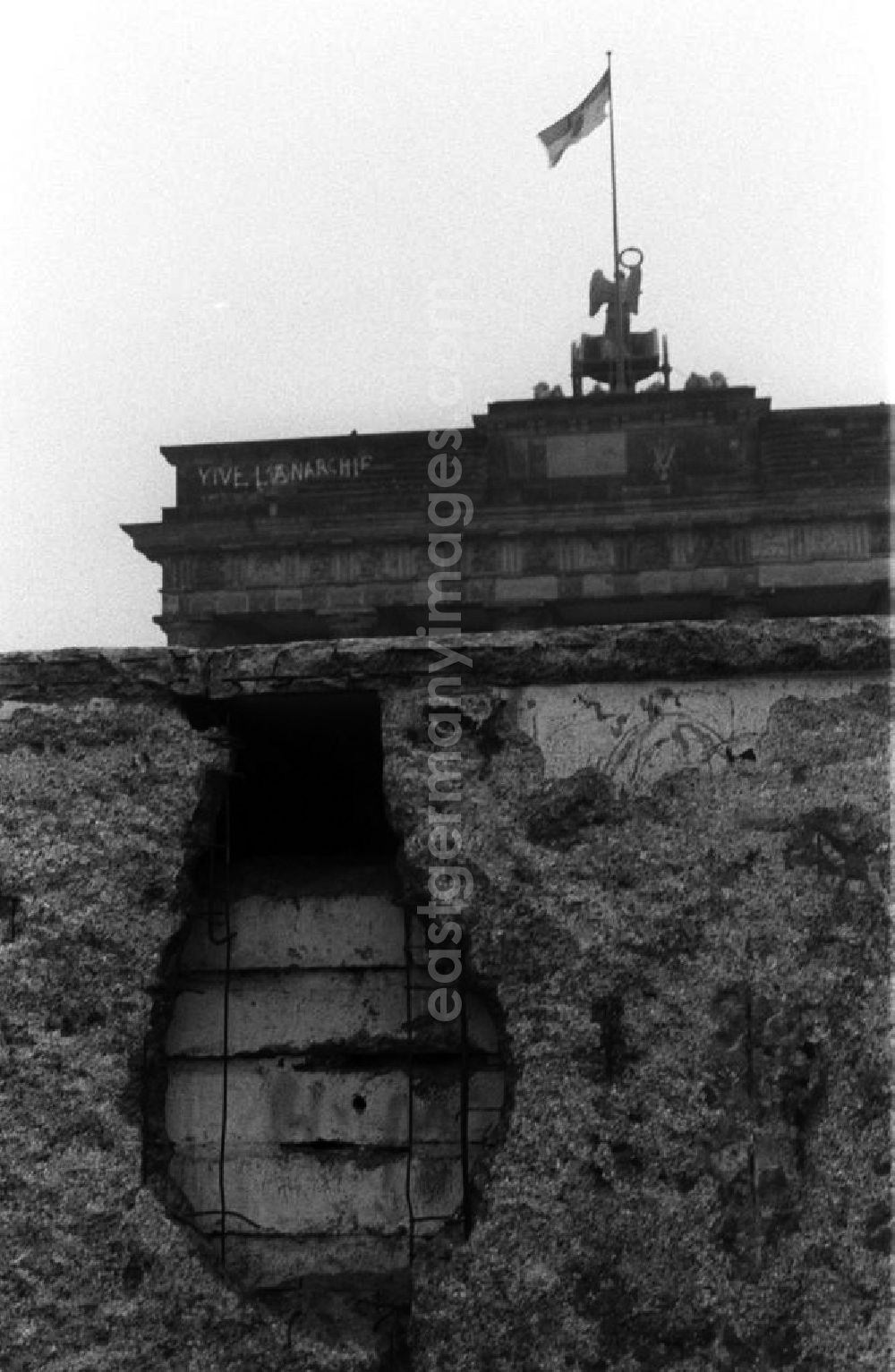 GDR photo archive: Berlin - Blick über die bereits löschrige Mauer auf das Brandenburger Tor. Als Erinnerung wurden gern Stücke der Mauer mitgenommen, so entstanden die Löscher, sie hießen auch Mauerspechte.