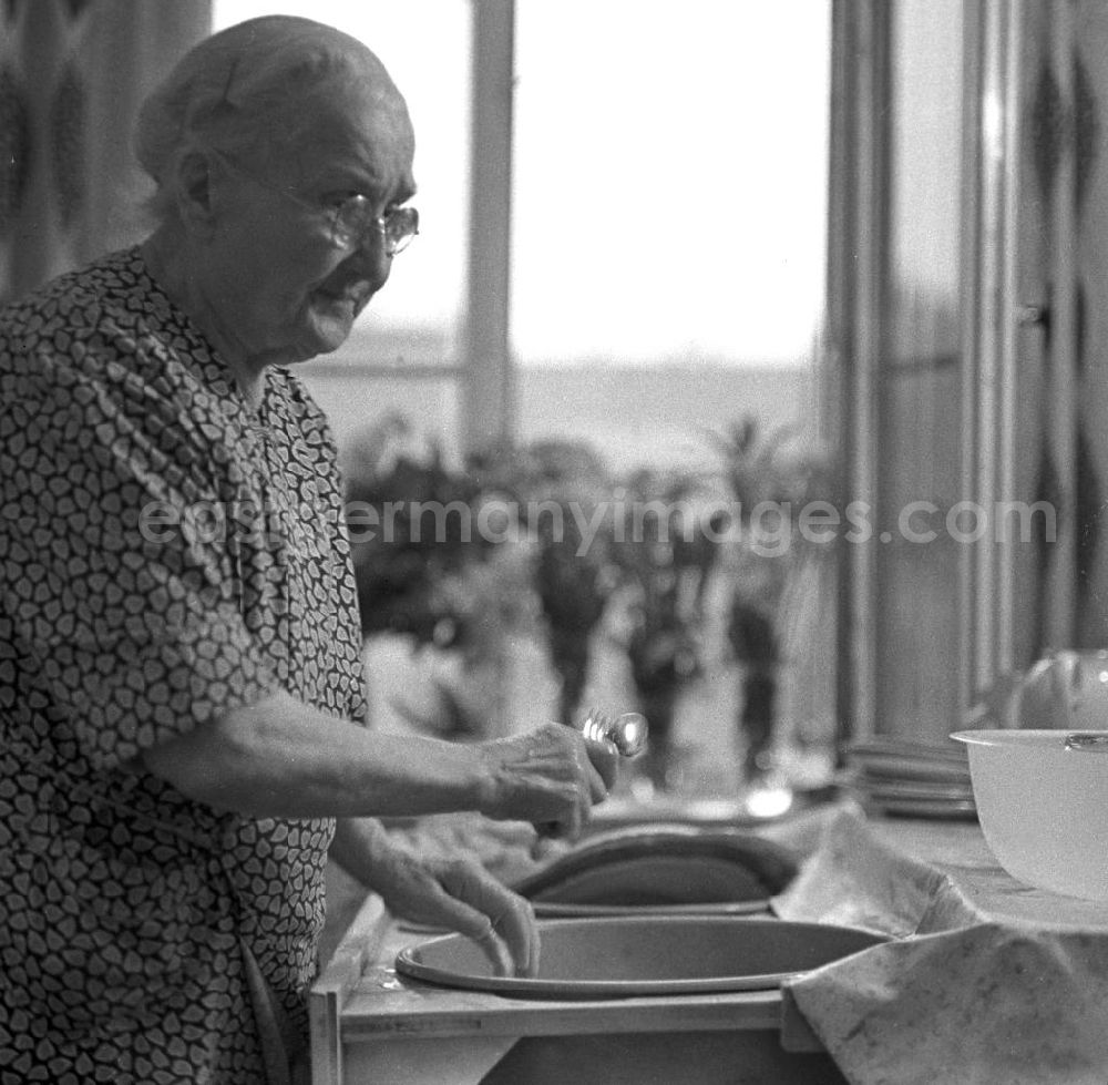 GDR picture archive: Leipzig - Eine alte Frau wäscht an einem Spülschrank ihr Geschirr ab.
