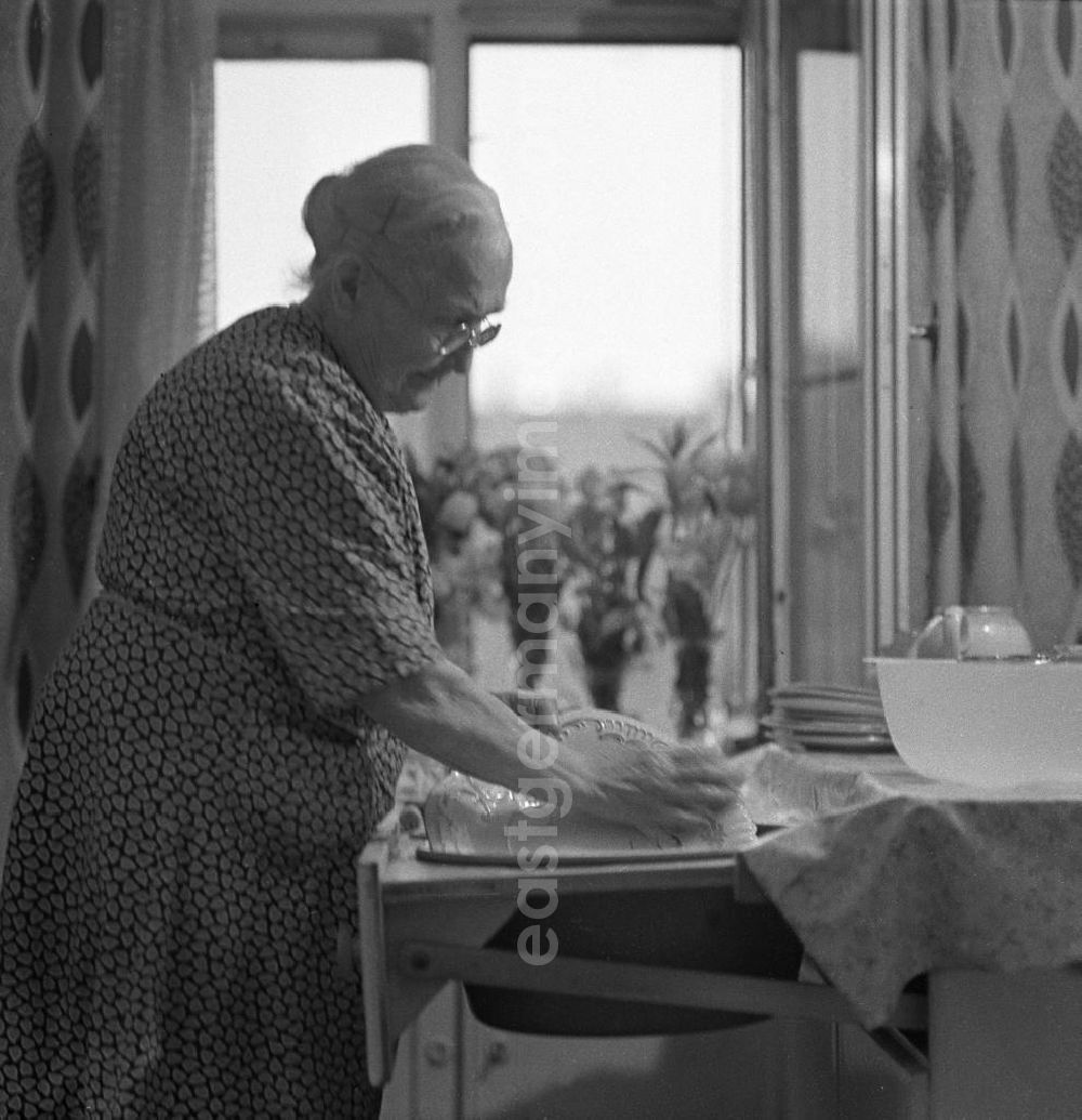 GDR photo archive: Leipzig - Eine alte Frau wäscht an einem Spülschrank ihr Geschirr ab.