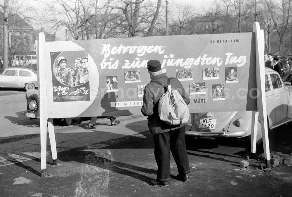GDR photo archive: Leipzig - Ein alter Mann betrachtet in Leipzig einen Werbeaufsteller für den DEFA-Film Betrogen bis zum jüngsten Tag. Der Anti-Kriegsfilm lief während der Internationalen Filmfestspiele Cannes im Jahr 1957, aufgrund der Intervention der BRD jedoch nur im Rahmenprogramm. Dennoch erhielt er internationale Anerkennung.