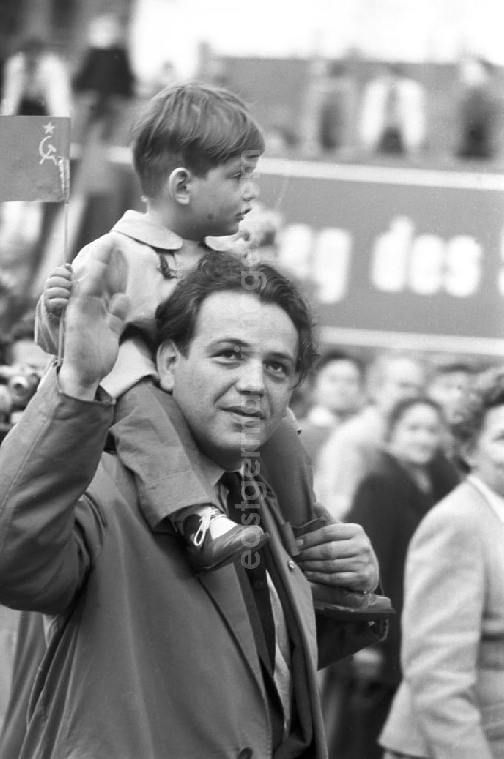 GDR picture archive: Leipzig - Auf der Demonstration zum 1. Mai 1958 in Leipzig sitzt ein Junge auf den Schultern seines Vaters und hält eine Sowjet-Fahne in der Hand.
