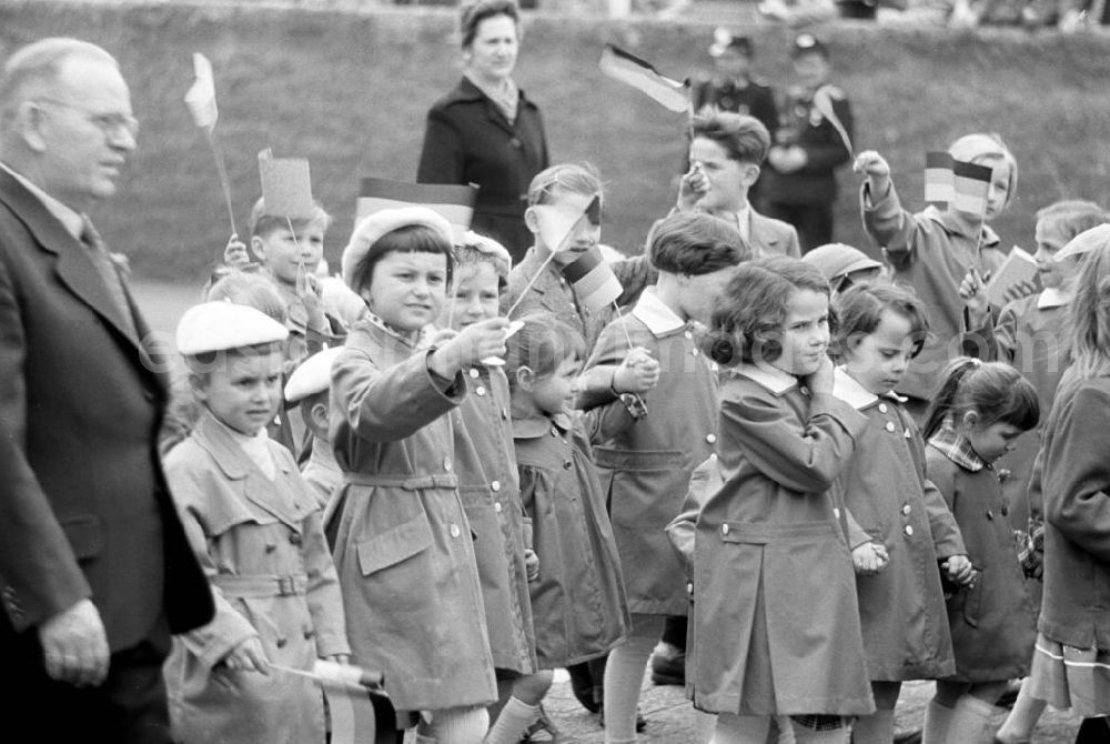 GDR photo archive: Leipzig - Kinder winken mit DDR-Fähnchen auf der Demonstration zum 1. Mai 1958 in Leipzig. Die Fahnen sind noch ohne das erst am 1. Oktober 1959 offiziell eingeführte DDR-Emblem aus Hammer, Zirkel und Ehrenkranz.