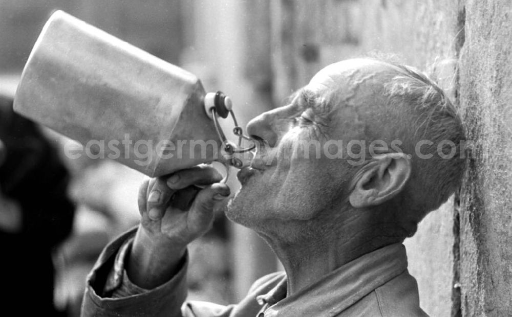 GDR photo archive: Leipzig - Ein alter Mann in Arbeitskleidung macht eine Pause und trinkt aus einer Trinkflasche.