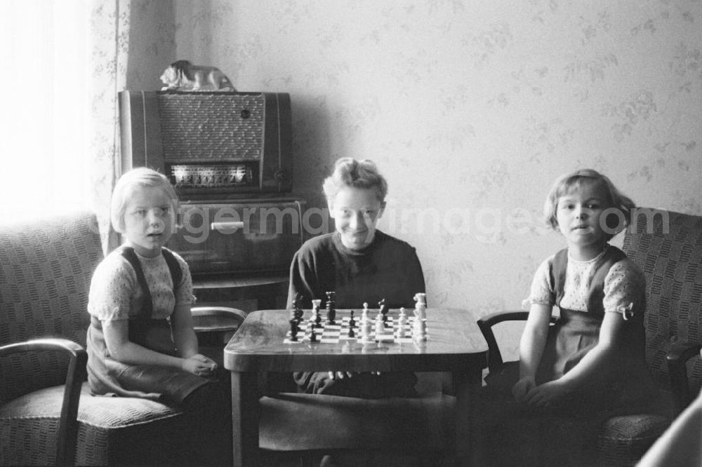 GDR photo archive: Leipzig - Kinder posieren am Schachtisch mit aufgebauter Schachpartie für ein Gruppenfoto in Leipzig. Im Hintergrund ein Röhrenradio.