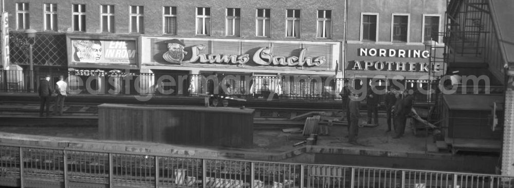 GDR picture archive: Berlin - Mit großen Buchstaben laden das Kino Skala, das Schuhgeschäft Hans Sachs und die Nordring Apotheke in der Schönhauser Allee in Berlin zu einem Besuch ein. Entlang der Schönhauser Allee, der beliebtesten Einkaufsstraße im Berliner Osten, verläuft die U-Bahnlinie über der Erde.