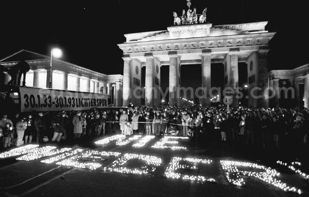 GDR photo archive: Berlin-Mitte - Nachtaufnahme: Lichterkette gegen Ausländerhass am Brandenburger Tor. Kerzen stehen auf Boden zusammen und bilden den Schriftzug NIE WIEDER. Plakat mit der Aufschrift 30.1.33-3