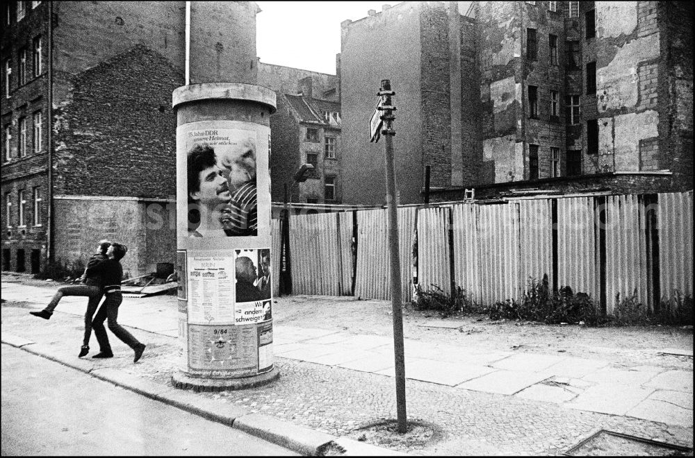 Berlin: Advertising as a contrast to the dilapidated reality in the old residential area on the Scheunenviertel on an advertising pillar on a sidewalk on Max-Beer-Strasse in the Mitte district of Berlin East Berlin in the area of the former GDR, German Democratic Republic