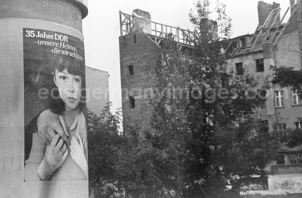 GDR image archive: Berlin - Advertising as a contrast to the dilapidated reality in the old residential area on the Scheunenviertel on an advertising pillar on a sidewalk on Max-Beer-Strasse in the Mitte district of Berlin East Berlin in the area of the former GDR, German Democratic Republic
