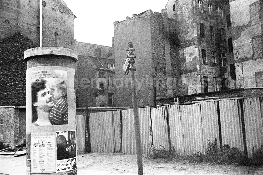 GDR picture archive: Berlin - Advertising as a contrast to the dilapidated reality in the old residential area on the Scheunenviertel on an advertising pillar on a sidewalk on Max-Beer-Strasse in the Mitte district of Berlin East Berlin in the area of the former GDR, German Democratic Republic