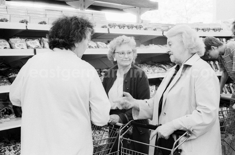 GDR photo archive: Berlin - 3 elderly ladies chatting in a department store in Berlin, the former capital of the GDR, the German Democratic Republic. The shelves are filled partly with Ostprodukten as well with Western products