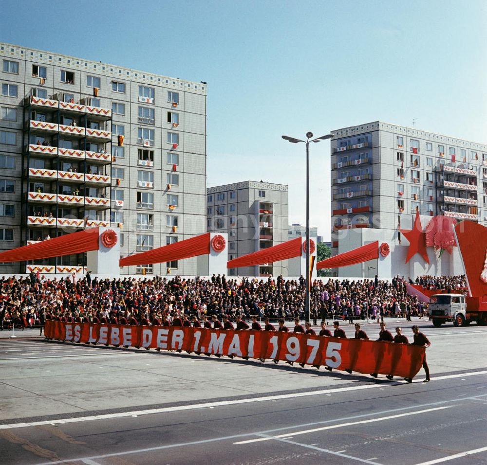 GDR image archive: Berlin - Ein Spruchband Es lebe der 1. Mai 1975 wird bei der traditionellen Demonstration in der Hauptstadt der DDR, dem Internationalen Kampf- und Feiertag der Werktätigen für Frieden und Sozialismus, vor der Ehrentribüne vorbeigetragen, aufgenommen auf der Berliner Karl-Marx-Allee.