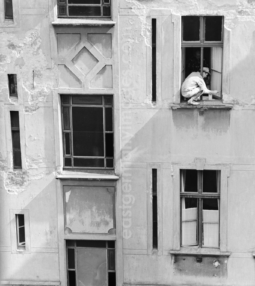 GDR photo archive: Berlin - A painter sweeps window in a backyard in Berlin, the former capital of the GDR, the German Democratic Republic