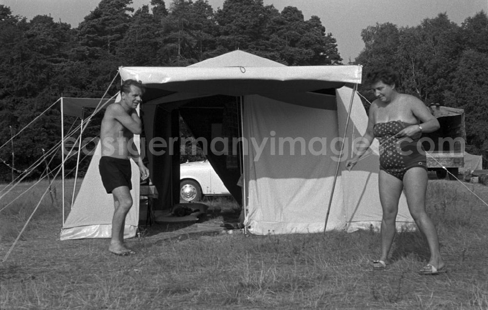 GDR picture archive: Neuruppin OT Stendenitz - Husband and wife jointly build on an awning. Family camping holidays at Rottstielfließ on Tornowsee in Brandenburg