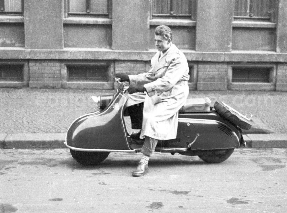 GDR photo archive: Weimar - Ein Mann, mit einem Trenchcoat bekleidet, posiert auf einem Pitty-Motorroller. Die Motorroller vom Typ Pitty wurden ab 1953 durch die Industriewerke Ludwigsfelde hergestellt / IWL. Bestmögliche Qualität nach Vorlage!