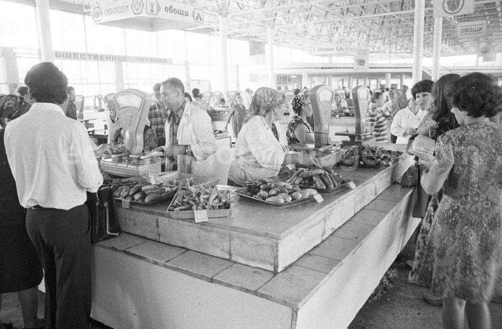 GDR picture archive: Wolgograd - Gemüsestand in einer Markthalle in Wolgograd (auch Wolograd). Verschiedene Gemüsesorten liegen auf der Theke neben Gemüsewaagen / Waagen, dahinter Verkäufer.