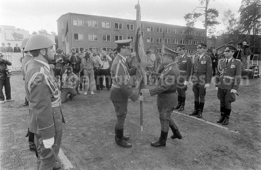 GDR picture archive: Goldberg - Return of the troop flag before the parade formation and march of soldiers and officers of Panzer Regiment 8 (PR-8) on the occasion of the ceremonial and media-effective dissolution of the troop unit on the grounds of the Artur-Becker barracks in Goldberg in the state of Mecklenburg-Western Pomerania on the territory of the former GDR, German Democratic Republic