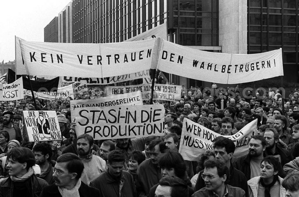 GDR photo archive: Berlin - Plakate mit politischen Forderungen werden am Berliner Palast der Republik mit dem Sitz der Volkskammer vorbei getragen. Berlin erlebt am