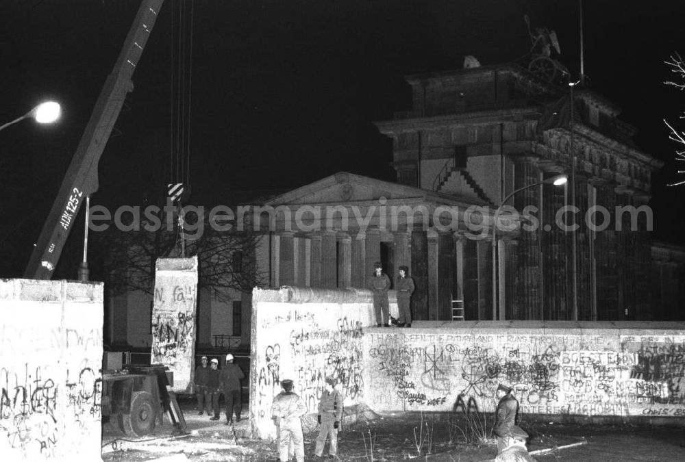 GDR photo archive: Berlin- Mitte - Nachtaufnahme: Maueröffnung / Mauerabbau am Brandenburger Tor. Kran hebt Mauerstück / Mauersegment.