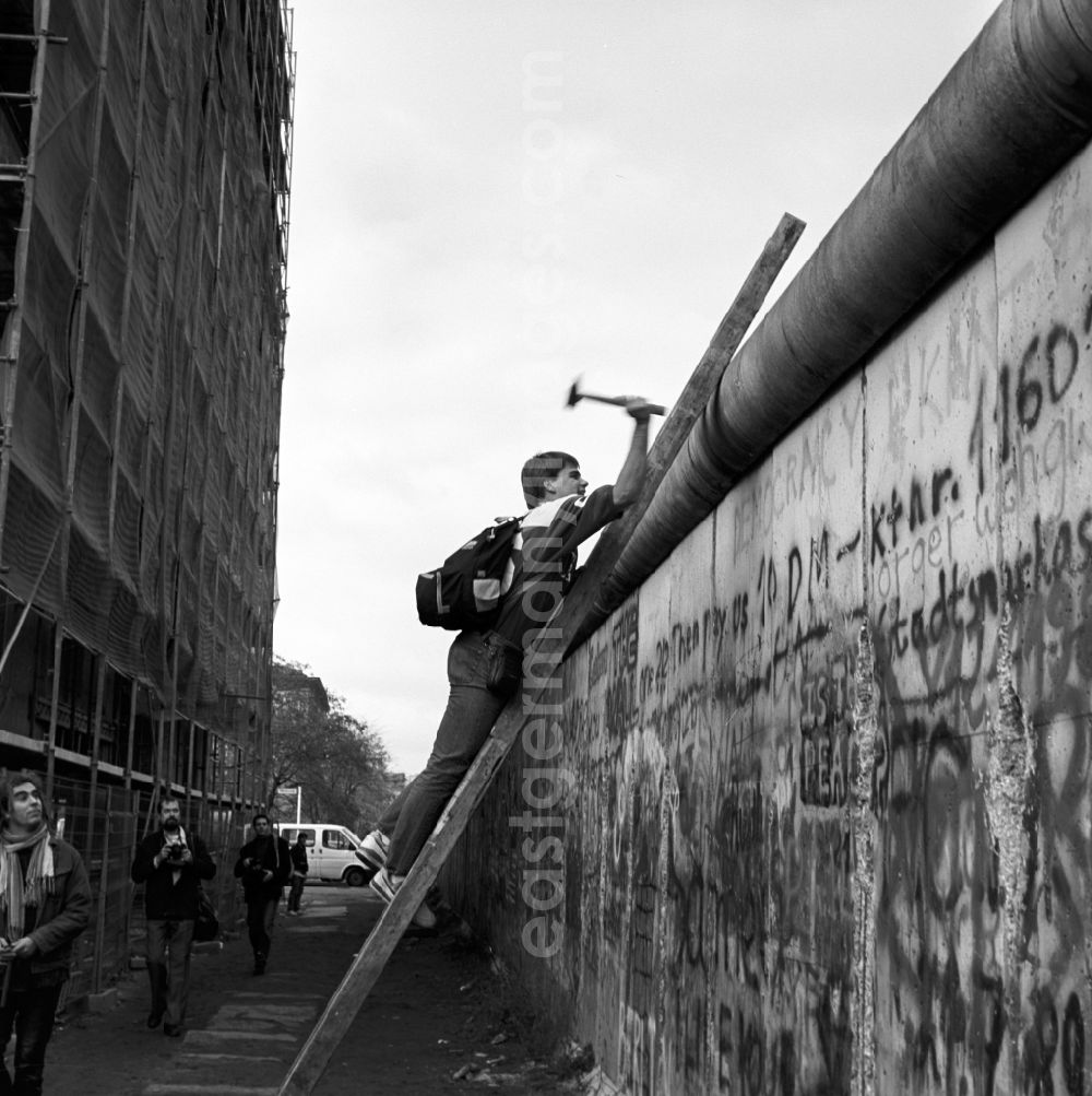 GDR picture archive: Berlin - Mitte - Wallpeckers at the Berlin Wall in Berlin - Mitte. As wallpeckers people were popularly known, edited the Berlin Wall after the Berlin Wall in 1989 and crushed