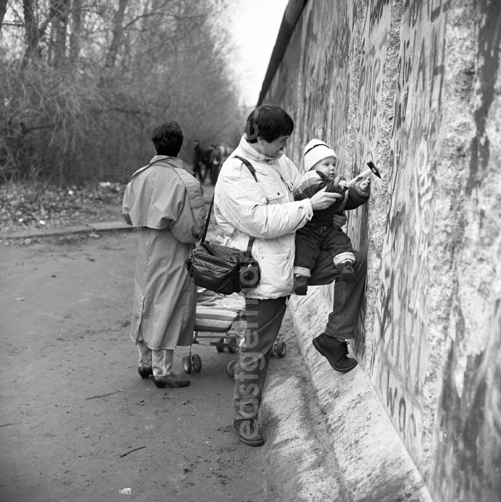 GDR photo archive: Berlin - Wallpeckers, to see a man with a toddler and Hammer, near the Brandenburg Gate in Berlin