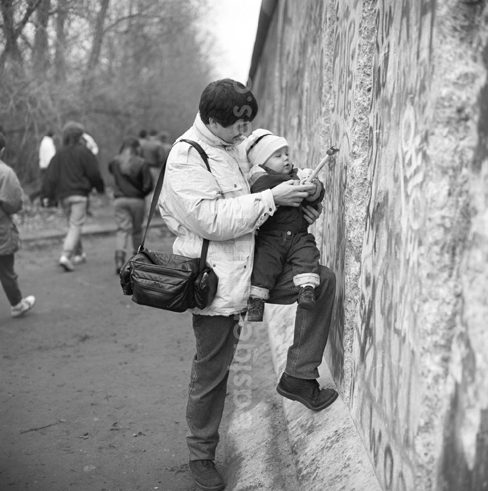 GDR picture archive: Berlin - Wallpeckers, to see a man with a toddler and Hammer, near the Brandenburg Gate in Berlin