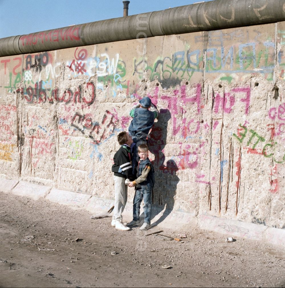 Berlin: Wallpeckers and souvenir collectors at the Berlin Wall in Berlin. As wallpeckers people were popularly known, the edited the Berlin Wall after the Wall fell in 1989 and crushed