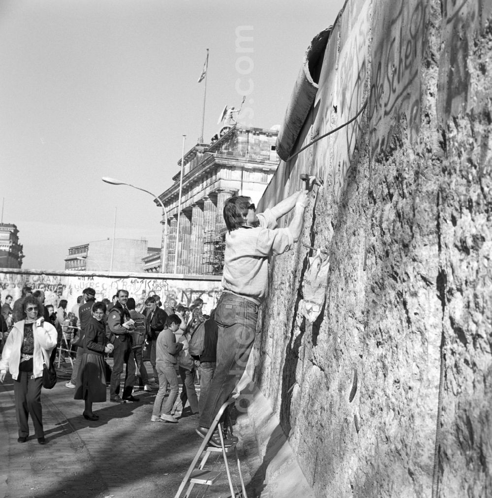 Berlin: Wallpeckers and souvenir collectors at the Berlin Wall at the Brandenburg Gate in Berlin. As wallpeckers people were popularly known, the edited the Berlin Wall after the Wall fell in 1989 and crushed